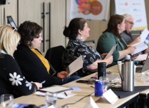 Meeting attendees sit at a table.