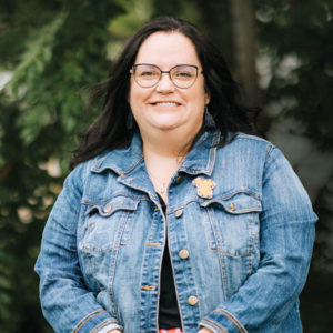 A female teacher wearing a jean jacket.